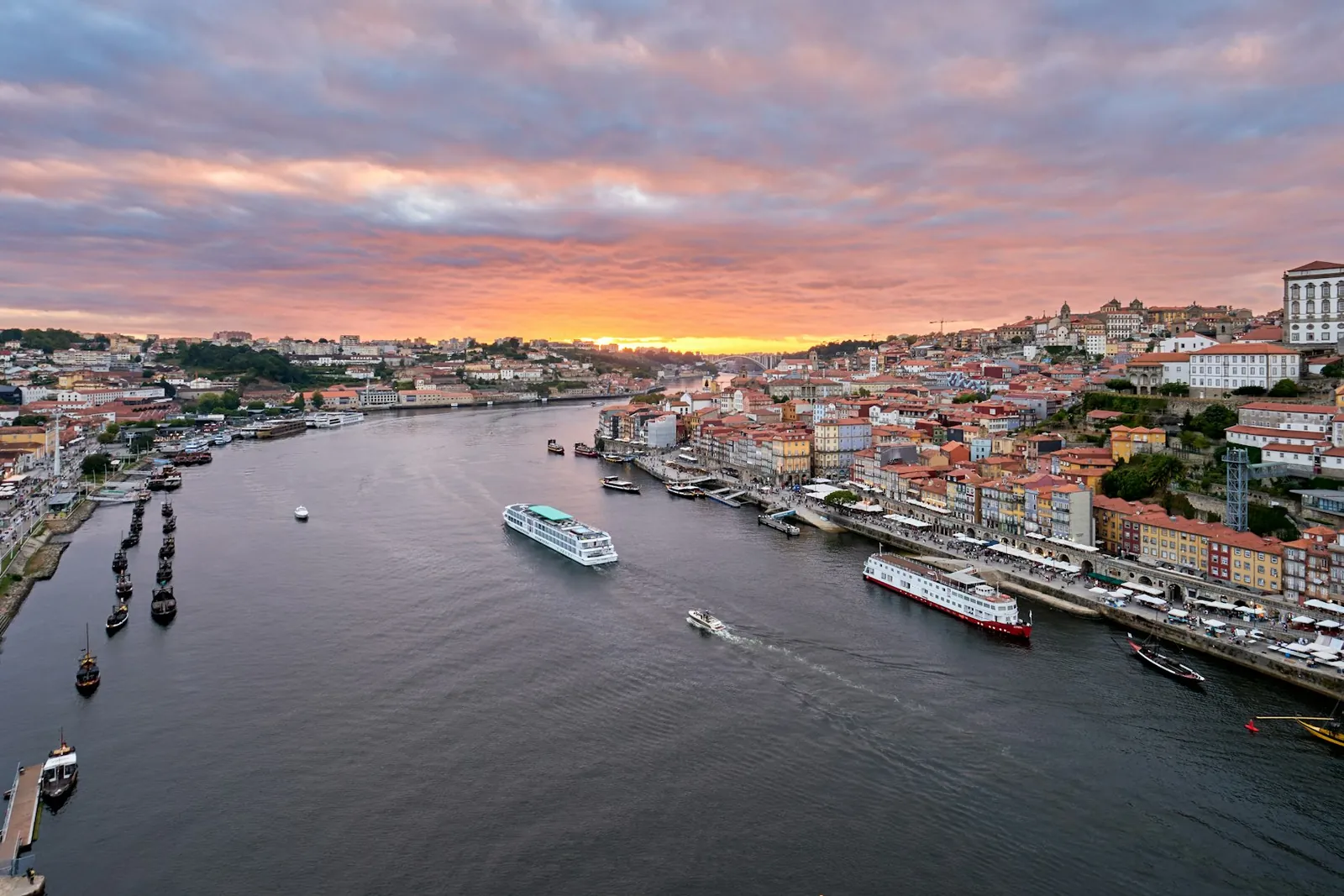 The Douro at sunset in Porto, boats moored below the terraced old town.